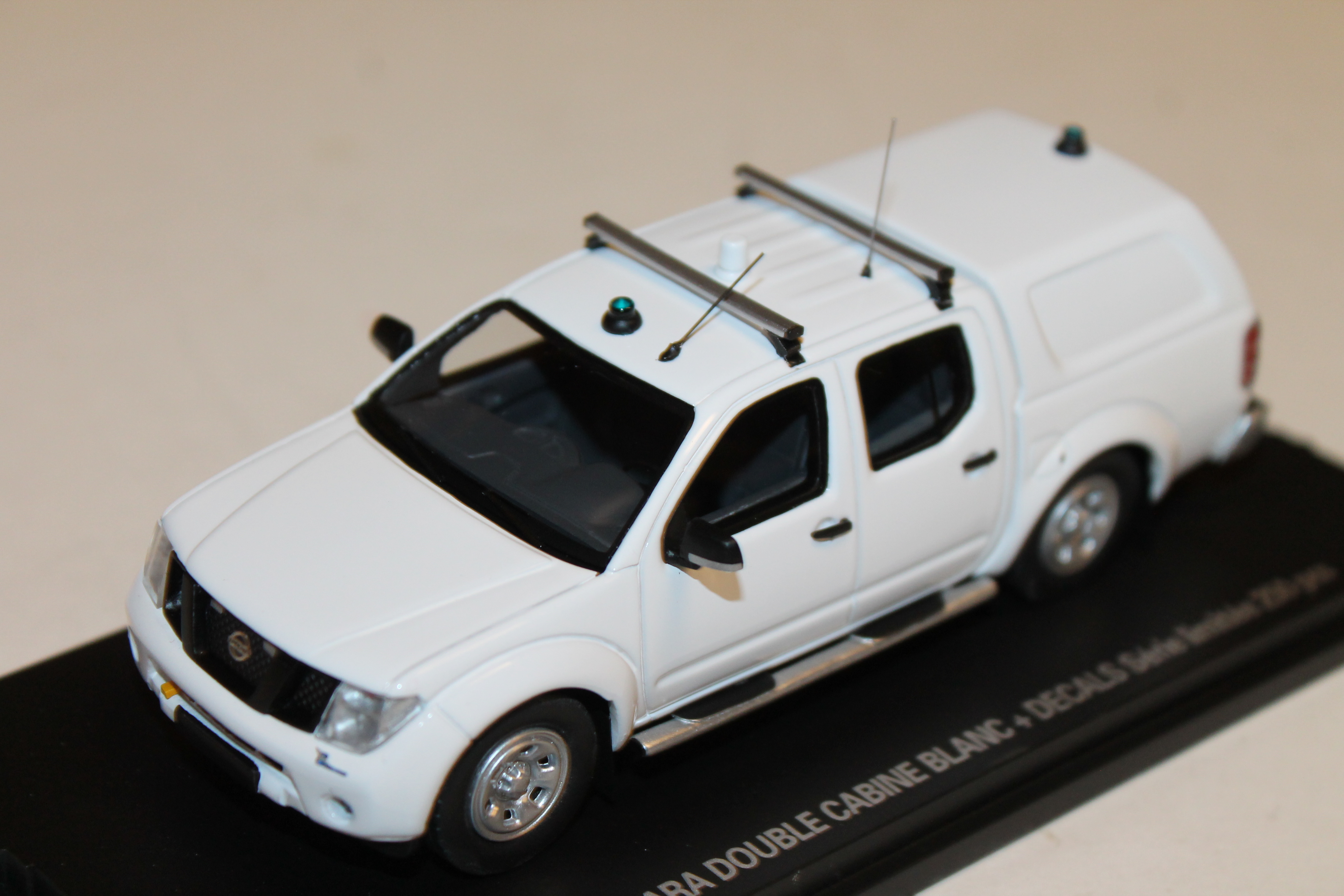 NISSAN NAVARA DOUBLE CABINE BLANC + DECALS ALARME 1/43°